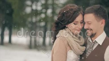 新婚夫妇在冬天降雪时微笑。